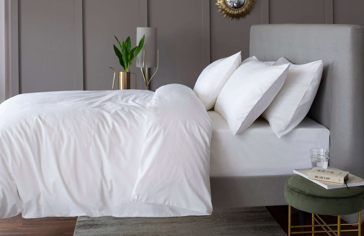 White cotton bed linen on a made bed
