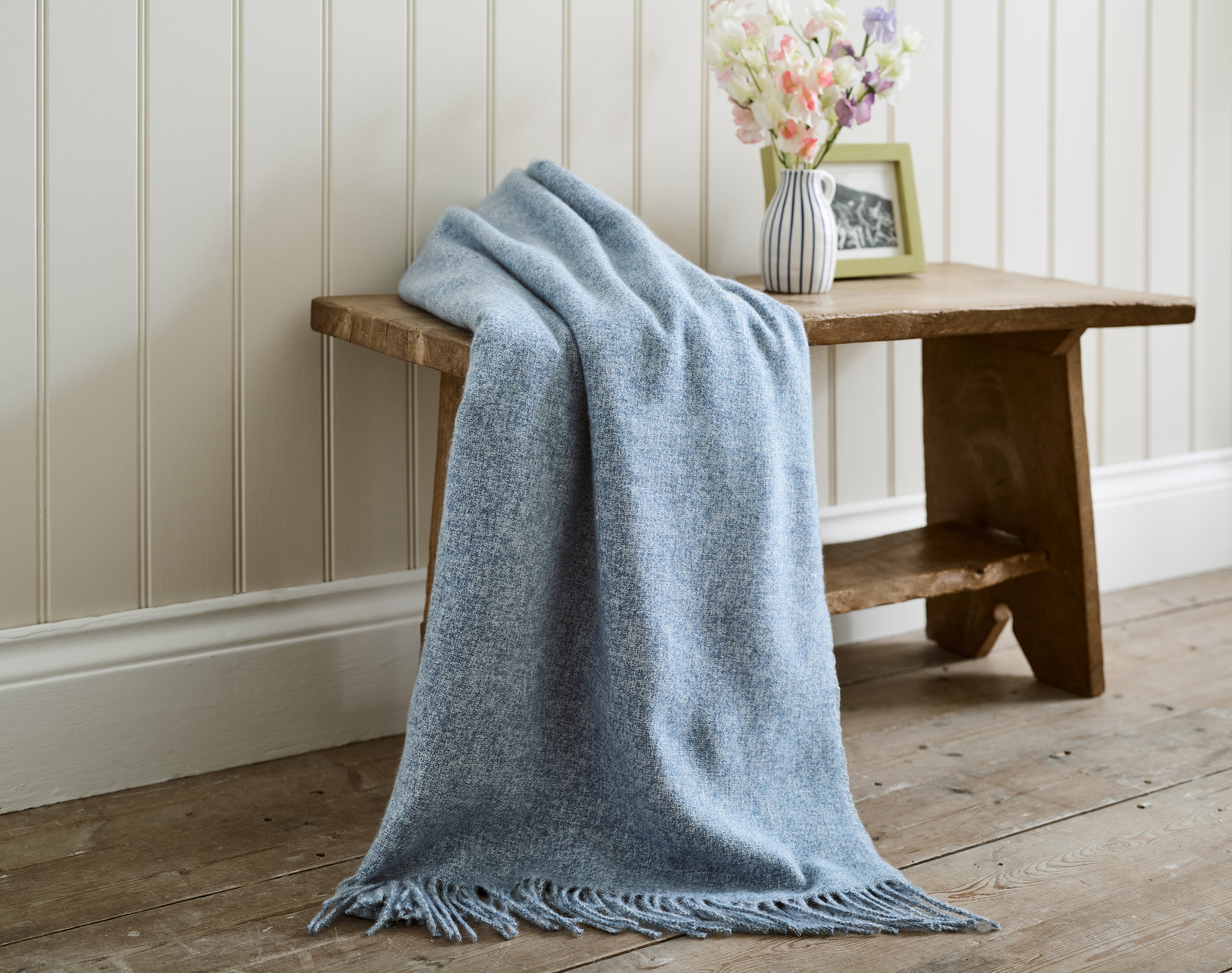 Arthington throw blanket in denim blue draped over a sofa
