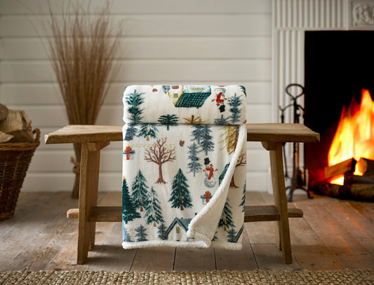 Flannel blanket with nature pattern draped over a wooden chair in front of a fireplace.