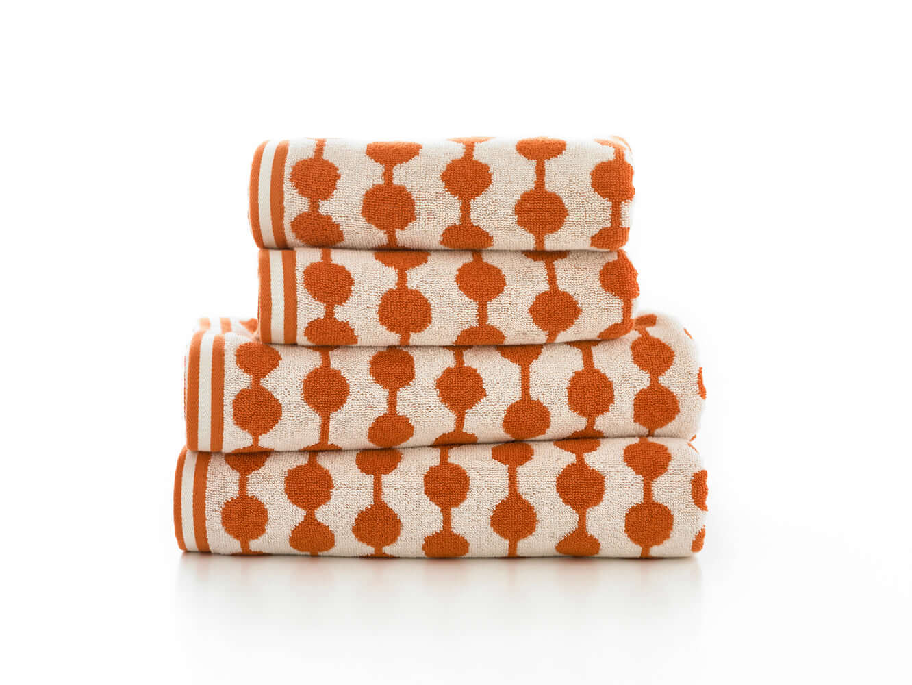 Stack of absorbent cotton towels in bold orange and white design, perfect for luxury bathrooms and stylish spa settings.