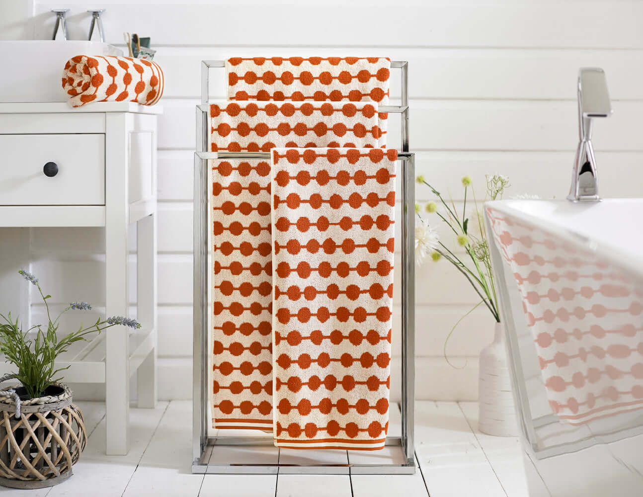 Soft, absorbent cotton towels in bold orange dot pattern, perfect for bathroom or spa, by Deyongs.